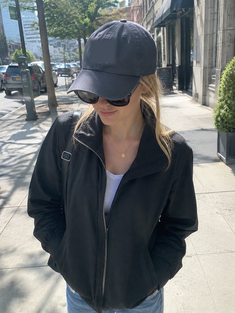 Dark sunglasses and a cap brim shading a face